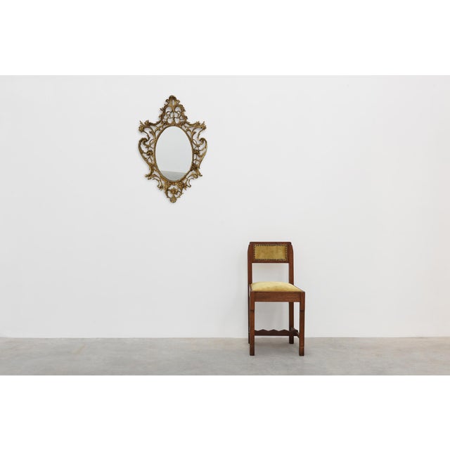 An elegant Italian Rococo Revival wall mirror featuring a richly ornamented openwork gilt-colored cast metal frame. The...