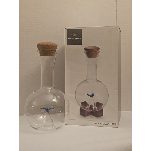 This 1990s Wine Decanter is hand blown glass with a blue bird aerator, cork stopper and a removable acacia wood trivet. It...