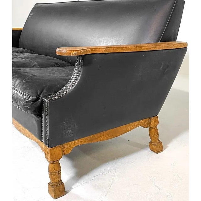 A mid century, c. 1960's, Danish modern leather sofa with an exposed wood frame and arm rests. A very nicely designed sofa...