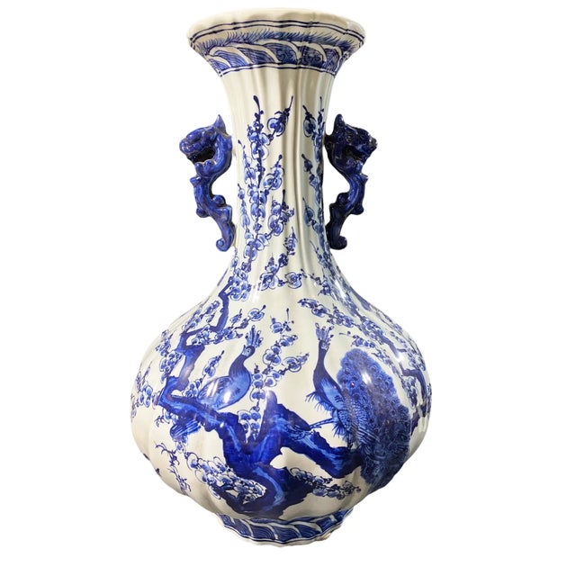 Superb hand-painted large Chinoiserie vase features a striking blue and white design with intricate floral, peacock, and...