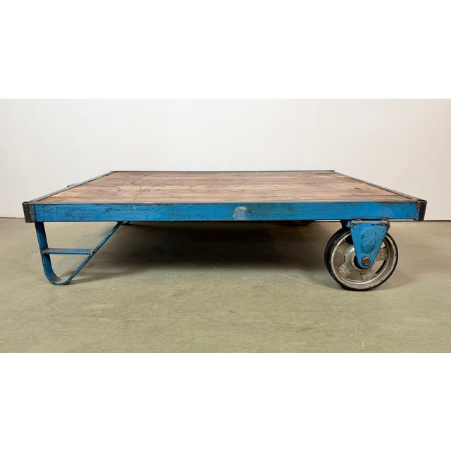 Former pallet truck from a factory now serves as a coffee table. It features a blue iron construction with two original...
