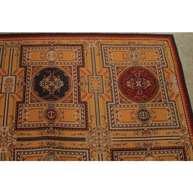 Handmade in wool originating from China circa 1980-1990, a vintage 5x7 needlepoint ode to Axminster rug styles joining Rug...
