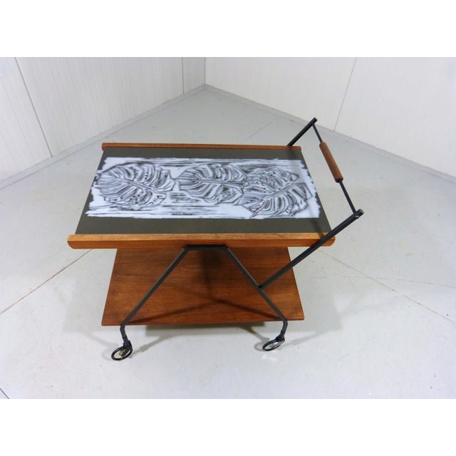 Very nice trolley with a large tile as top. Black square steel frame, unusual black and clear plastic wheels, beneath a...