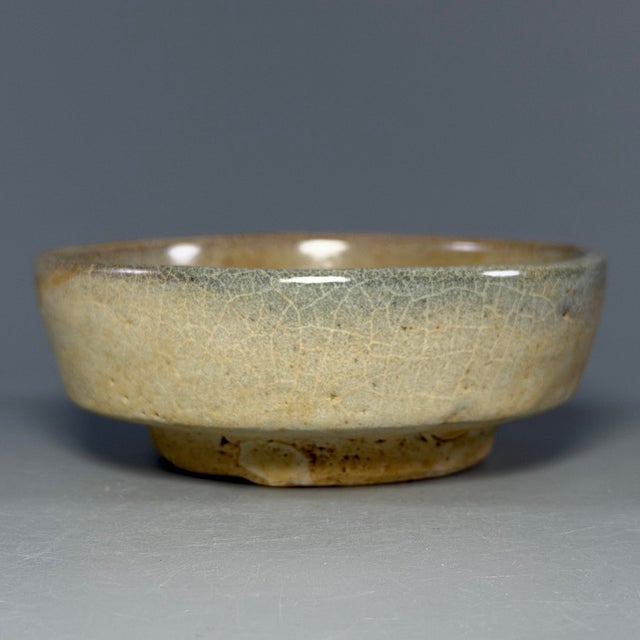 This antique Chinese shallow dish features soft yellow glaze with natural aged texture. A fine collectible ceramic piece...