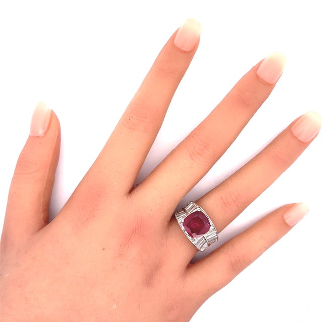 A captivating ruby, weighing 4.21 carats, is the focal point of this contemporary ring. The antique cushion-cut stone...