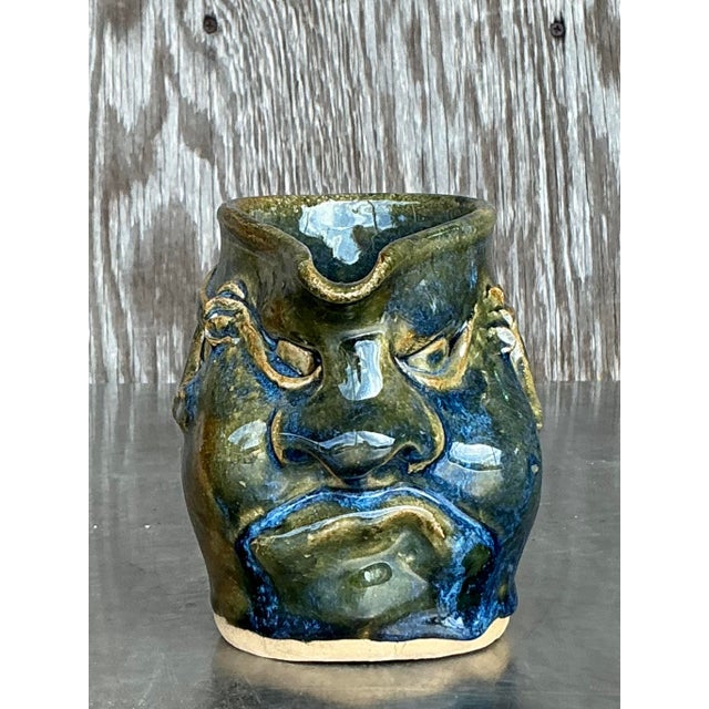 This striking vintage studio pottery face pitcher is a true one-of-a-kind piece, blending functionality with expressive...