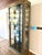 Mastercraft model 21-420 china cabinet vitrine. Clad in antiqued brass with black lacquer trim. Backwall is smoked...