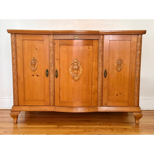 1950s Italian honey pine sideboard buffet. Features ample space for storage with three doors with applied fruit carvings...