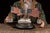 Handcrafted folk art whirligig featuring a circular arrangement of painted American flags mounted on wire supports,...