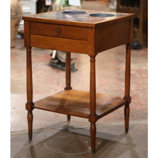A refined example of a traditional French rafraîchissoir, this antique walnut table was designed as a convenient serving...