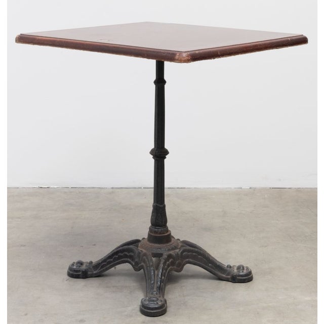 Vintage European Bistro Table in walnut finish with brass plate - #4. Heavy metal decorative base approximately 16" wide.