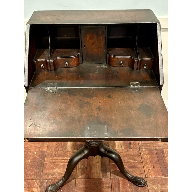 An unusual antique slant-front writing desk on a carved tripod pedestal stand, dating to the 19th century, circa...