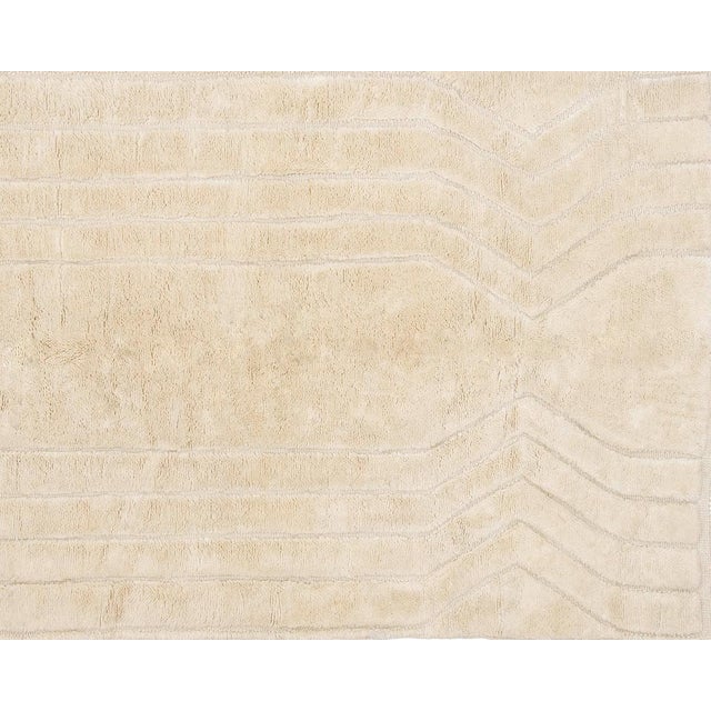 Exquisite Ivory rug, meticulously hand-knotted with a captivating design of flowing lines. This delicate yet unique...