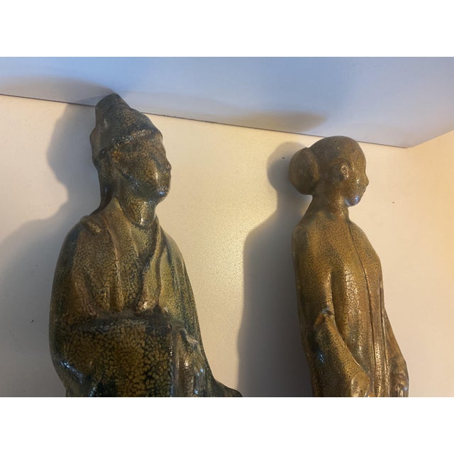 Decorative pair of vintage ceramic figures depicting traditional robed scholars or dignitaries in an Asian-inspired style....