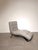 Elegant modern chaise lounge upholstered in high-quality light grey leather. Its flowing ergonomic silhouette provides...