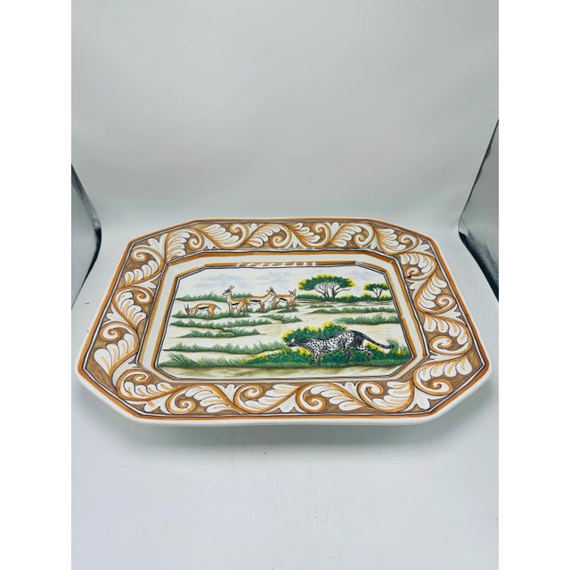 This is a hand-painted ceramic platter with a decorative and narrative design. Front Design • Central Scene: The inner...
