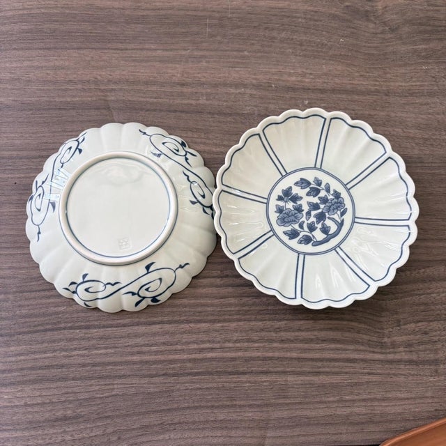 A pair of blue and white ceramic plates with chrysanthemum-petal-shaped rims; decorated with finely and elegantly rendered...