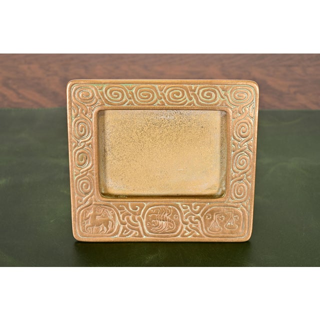 A gorgeous antique Art Deco or Arts & Crafts period gilt bronze desk calendar holder or picture frame featuring symbols of...