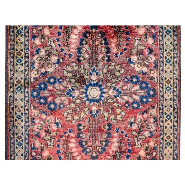 A traditional early 20th century Persian Sarouk rug with a mirrored tree-of-life pattern woven in indigo, brown, beige,...