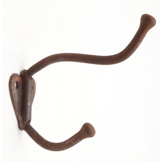 Vintage cast iron double arm wall hook with a rusted japanned finish. The original mounting screws are not available. Good...