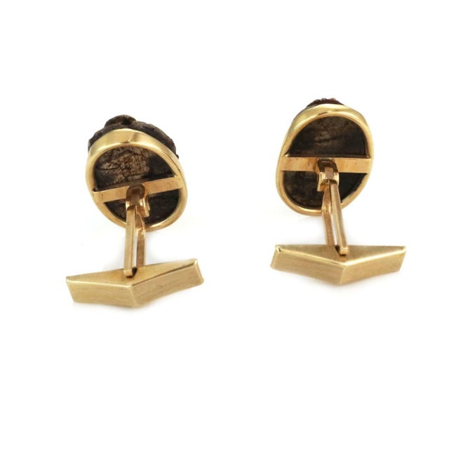 This is a vintage collectible pair of cufflinks. It is crafted from 14k yellow gold featuring a treated wood design...