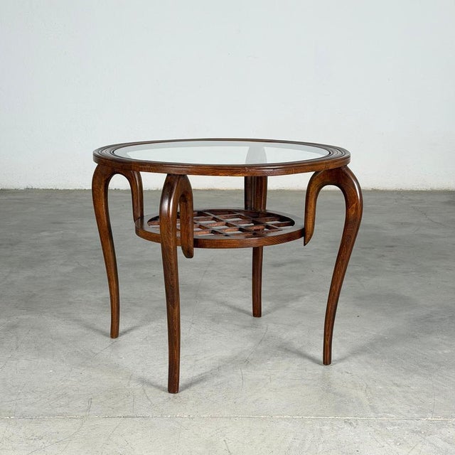 Elegant and sculptural, this Italian coffee table—attributed to Paolo Buffa and produced by Arrighi Serafino in the...