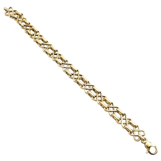 An iconic Tiffany & Co. bracelet crafted in 18k yellow gold, featuring an intricate basket-weave pattern of interlaced...