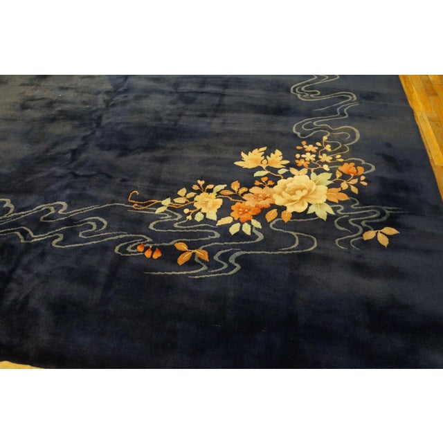 The border-less open royal blue field shows a large and a small floral bouquet diagonally opposed, but linked by a...