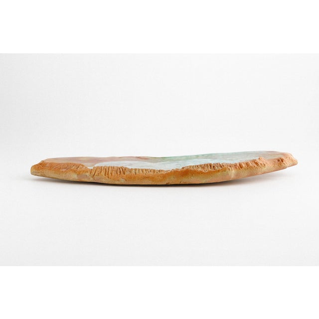 A slab-form raku tray by Tony Evans with pastel surfaces and impressed shell patterns. The carved edges and thick walls...