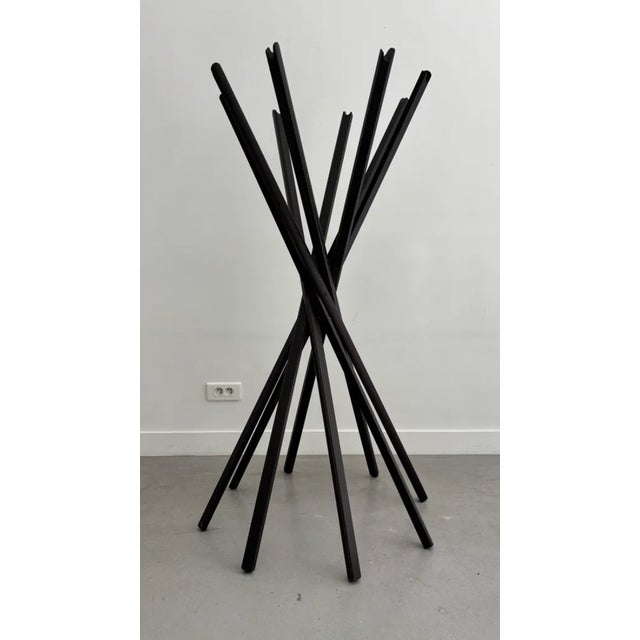 The "Sciangai" coat rack, inspired by the Chinese game "Mikado," consists of eight solid wood slats connected by a central...