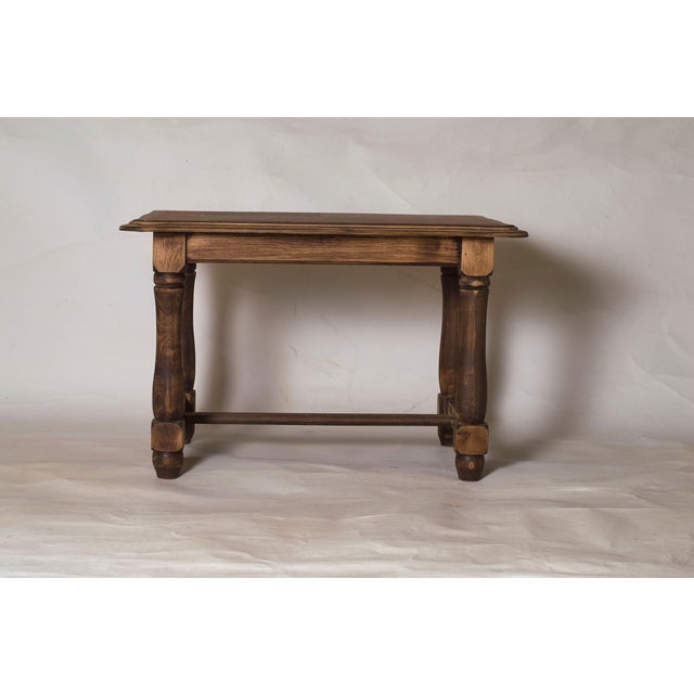 Crafted from solid wood, the table features a subtly shaped top adorned with a geometric veneer that highlights the...