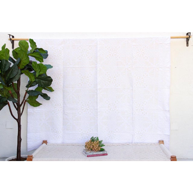 A lightweight cotton coverlet from Western India, beautifully adorned with intricate handcrafted appliqué cutwork. The...