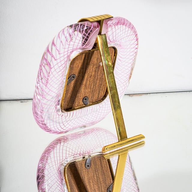 Pair of table frames in clear glass with pink thread inclusions. Fitted with brass mounts, inner frames, and rear support...