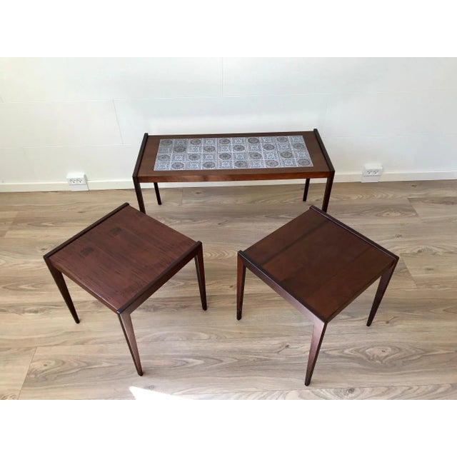 A nest of tables fashioned from teak and dark oak. The rectangular main table has inlaid tiles from Royal Copenhagen. Very...