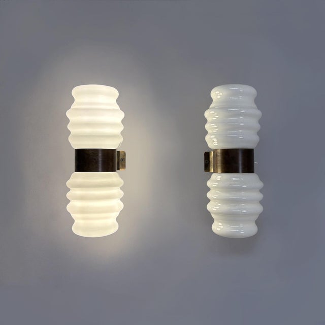 Italian mid-century modern wall lamps in opaline glass and brass, 1950s Wall lamps composed of two identical and...