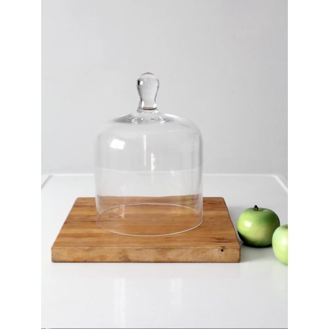 Vintage glass cloche featuring a classic dome form and rounded knob handle. Crafted from clear glass with a smooth, simple...
