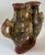This striking double‑chamber ceramic vessel features intricate hand‑painted geometric motifs in black and red on a warm...