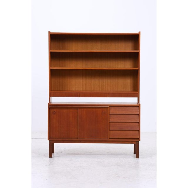 Vintage teak shelving unit in classic Danish design. The upper section offers ample open storage space, while below are...