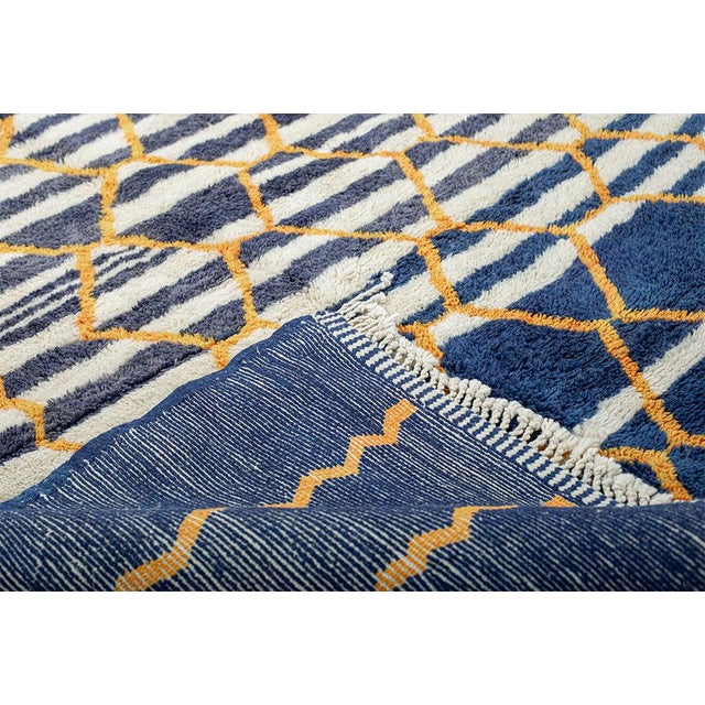 Abstract hand-knotted wool rug in deep Navy Blue and Ivory with vibrant Golden-yellow geometric and striped patterns. This...