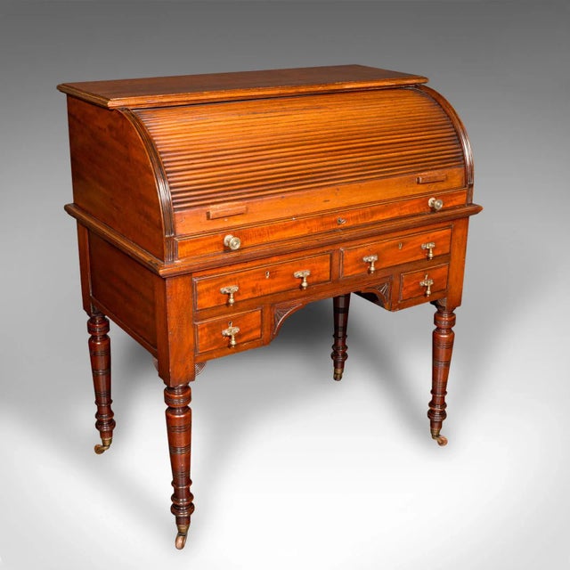 This is an antique roll-top desk. An English, mahogany and leather tambour bureau in Aesthetic Period taste, dating to the...