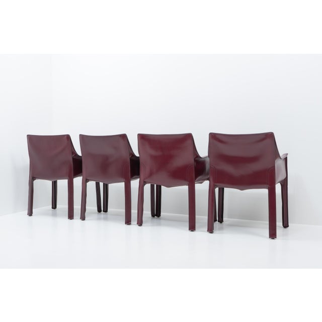 Set of four Cab 413 arm chairs in Bordeaux-red leather by Mario Bellini for Cassina. The Cab chair is built up as a...