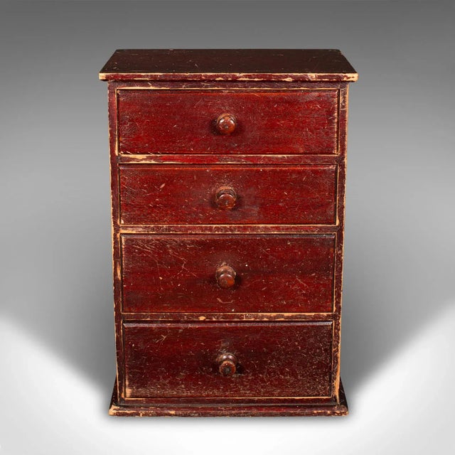This is a small set of antique apothecary drawers. An English, stained pine countertop chest, dating to the Edwardian...