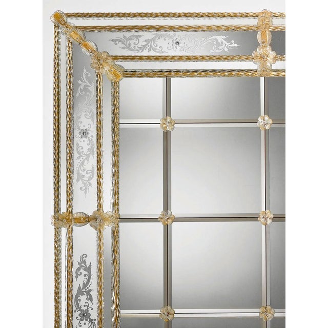 Handcrafted in Italy, this Venetian wall mirror features hand-engraved mirrored panels accented by decorative amber Murano...