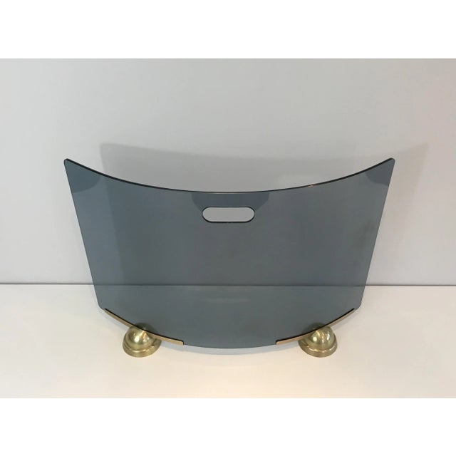 This very nice curved fire place screen is made of a brass base and a blue curved glass screen. This is a work by famous...