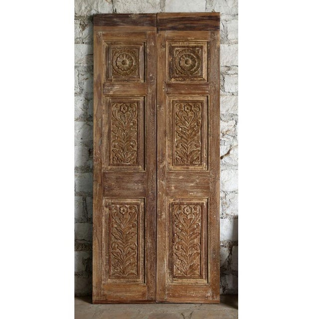 An exquisite pair of antique double closet doors showcasing delicate floral carvings inspired by classic French design....