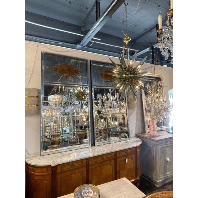 Gorgeous large scale pair of French Jansen style Eglomise sunburst Trumeau mirrors with beveled glass. This beautiful...