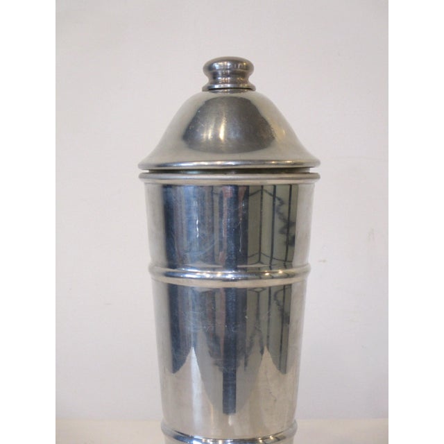 A very nice sized ribbed aluminum cocktail shaker with cone top , built in strainer and pour cap . Manufactured by the...