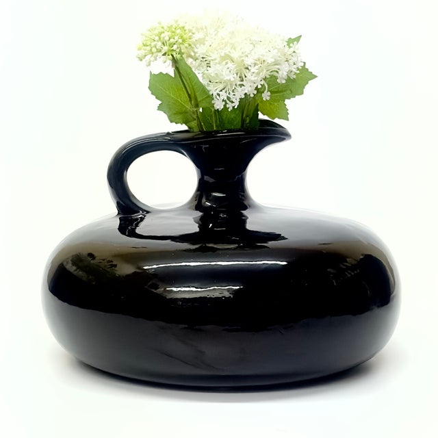 This is a gorgeous, rare 1980s large glossy black ribbed ceramic pitcher in the style of Royal Haeger featuring a low and...