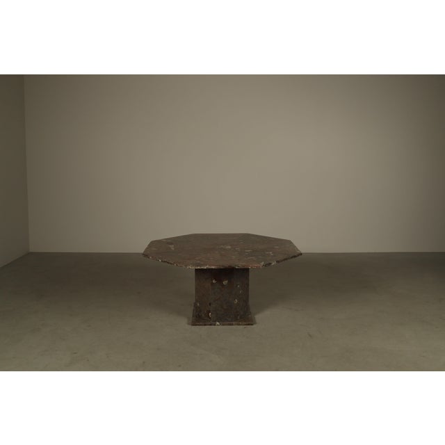Octagonal pedestal coffee table executed in fossil limestone, featuring a radially segmented tabletop articulated by fine...