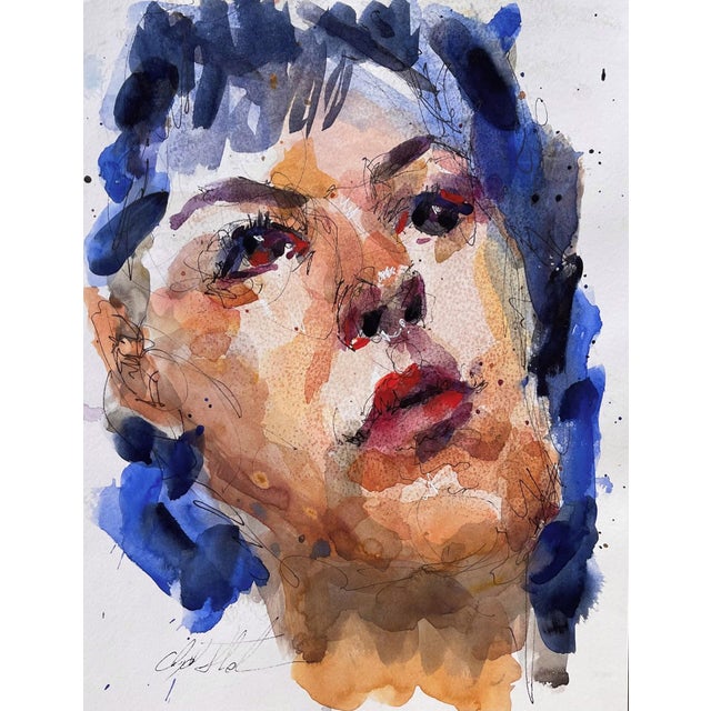 This watercolor work captures a close-up portrait, where fluid brushstrokes blend vibrant blues and warm skin tones to...